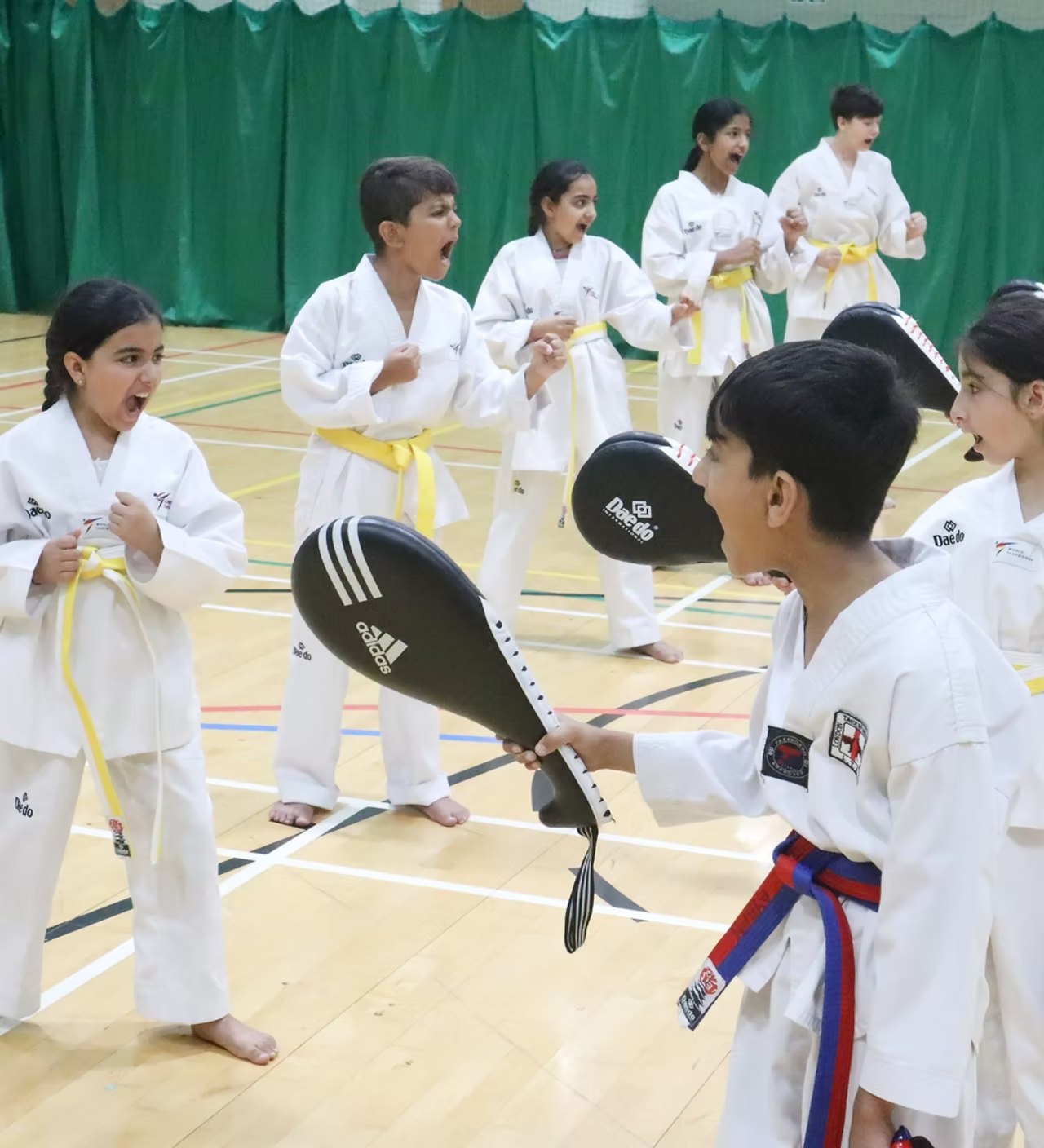 Children training Taekwondo with kick pads at a kids' martial arts class in Archway